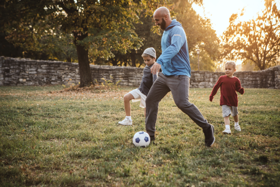 A man and kids playing soccer